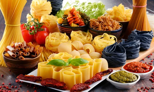 Composition with different sorts of pasta on kitchen table — Stock Photo, Image