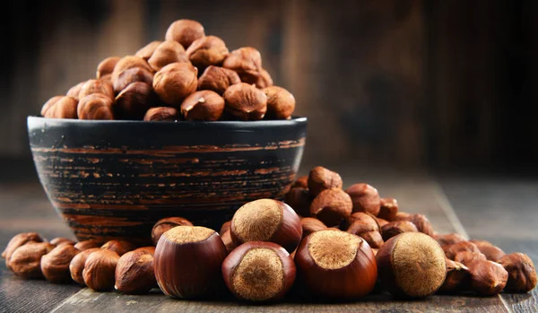 Bowl with hazelnuts on wooden table. — Stock Photo, Image