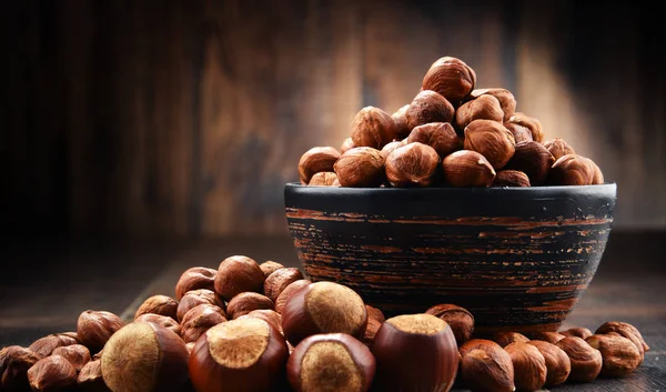 Skål med hasselnötter på träbord. — Stockfoto