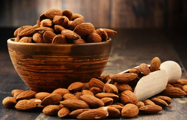 Cuenco con almendras sin cáscara sobre mesa de madera —  Fotos de Stock