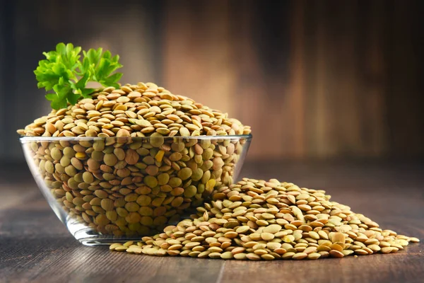 Composition with bowl of lentils on wooden table — Stock Photo, Image