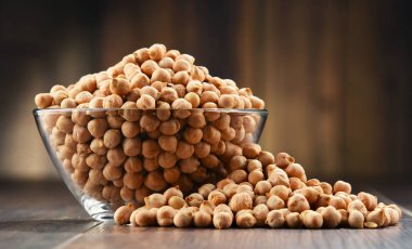 Ahşap masada bir kase nohut ile kompozisyon