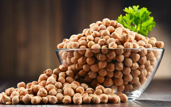 Composición con plato de garbanzos sobre mesa de madera —  Fotos de Stock