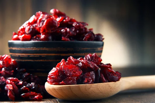 Composição com tigela de cranberries secas na mesa de madeira — Fotografia de Stock