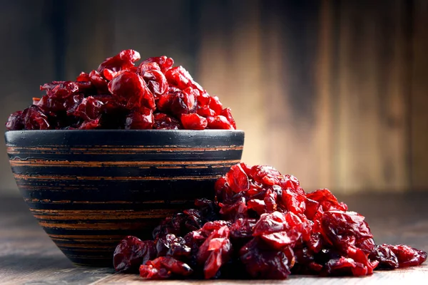 Composição com tigela de cranberries secas na mesa de madeira — Fotografia de Stock