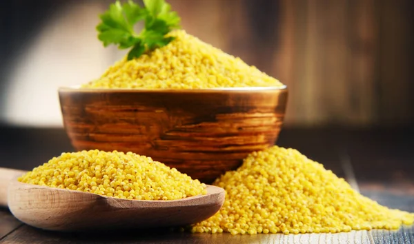 Composition with bowl of millet on wooden table — Stock Photo, Image