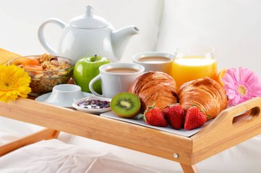 Otel odasında yatakta kahvaltı tepsisi