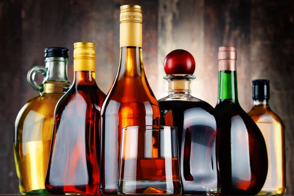 Glass and bottles of assorted alcoholic beverages — Stock Photo, Image