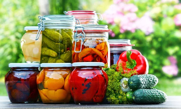 Frascos de legumes em conserva e frutas no jardim — Fotografia de Stock