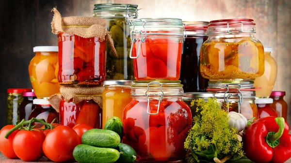 Jars with pickled vegetables and fruity compotes — Stock Photo, Image