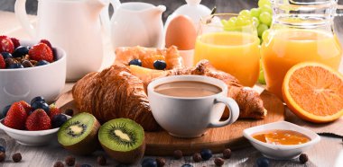 Breakfast served with coffee, juice, croissants and fruits clipart