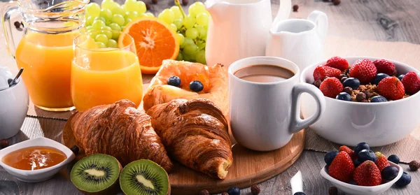 Café da manhã servido com café, suco, croissants e frutas — Fotografia de Stock