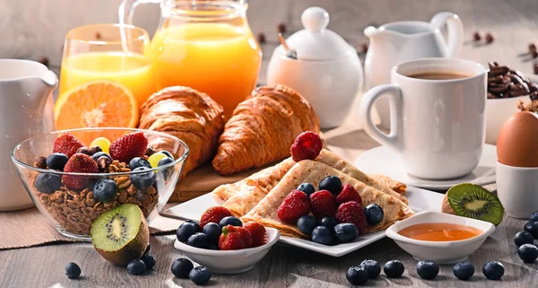 Café da manhã servido com café, suco, croissants e frutas — Fotografia de Stock