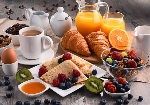 Morgenmad serveret med kaffe, juice, croissanter og frugt - Stock-foto