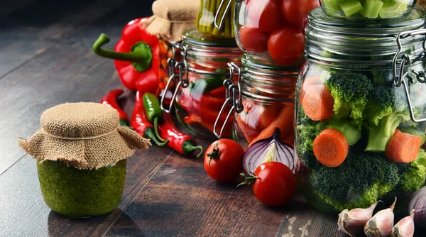 Jars with marinated food and organic raw vegetables — Stock Image Jars with marinated food and organic raw vegetables Royalty Free Stock Images