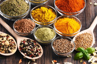 Mutfak masasında çeşitli baharat ve bitkiler var.