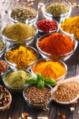 Mutfak masasında çeşitli baharat ve bitkiler var.