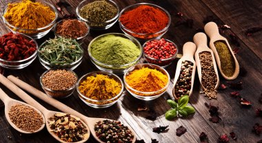 Mutfak masasında çeşitli baharat ve bitkiler var.