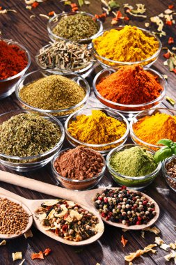 Mutfak masasında çeşitli baharat ve bitkiler var.