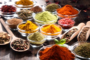 Mutfak masasında çeşitli baharat ve bitkiler var.
