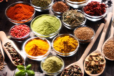Mutfak masasında çeşitli baharat ve bitkiler var.