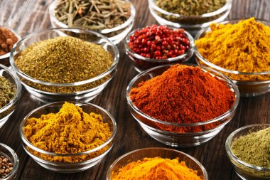 Mutfak masasında çeşitli baharat ve bitkiler var.