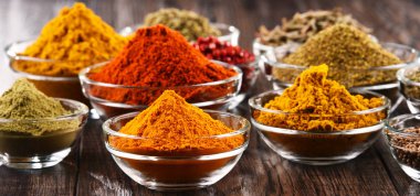 Mutfak masasında çeşitli baharat ve bitkiler var.