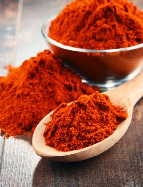 Ahşap masanın üzerinde bir kase biber tozu ile kompozisyon