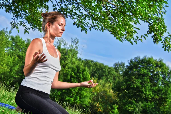 Młoda kobieta podczas medytacji jogi w parku — Zdjęcie stockowe