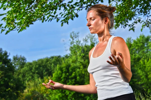 Молода жінка під час медитації йоги в парку — стокове фото