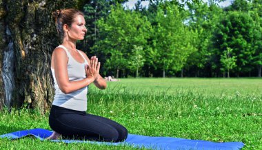 yoga, meditasyon sırasında genç kadın parkta