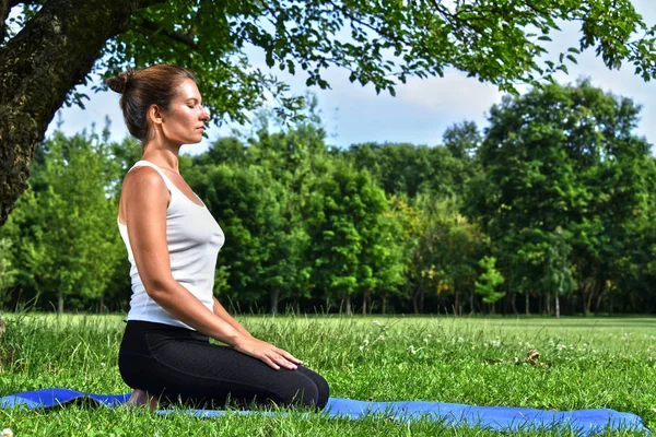 Yoga, meditasyon sırasında genç kadın parkta — Stok fotoğraf