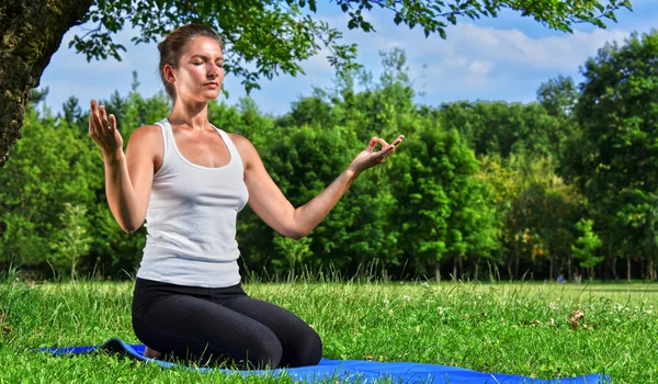 Yoga, meditasyon sırasında genç kadın parkta — Stok fotoğraf