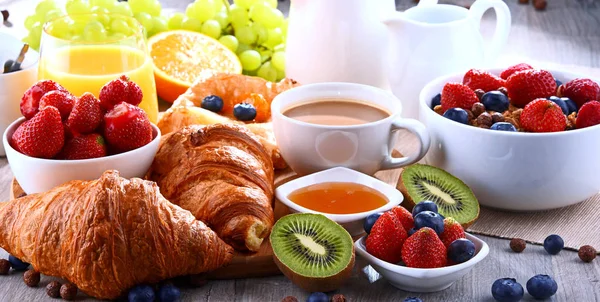 Café da manhã servido com café, suco, croissants e frutas — Fotografia de Stock