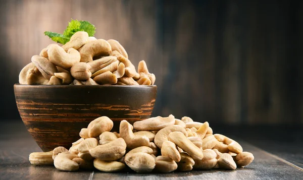 Schüssel mit Cashewnüssen auf Holztisch — Stockfoto