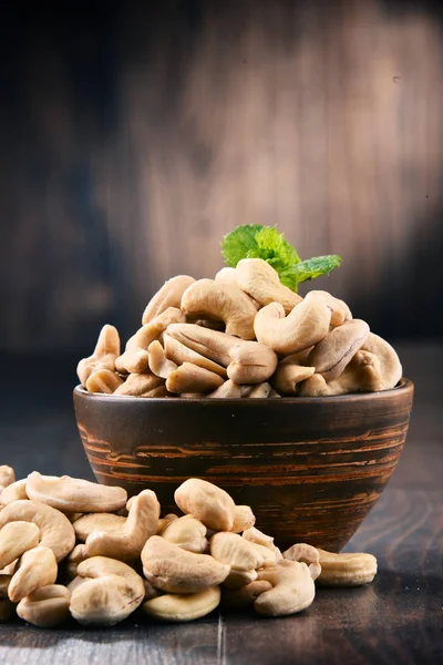 Mísa s Kešu ořechy na dřevěný stůl — Stock fotografie