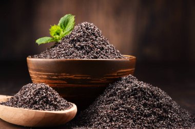 Ahşap masa üzerinde haşhaş tohumu kase ile kompozisyon