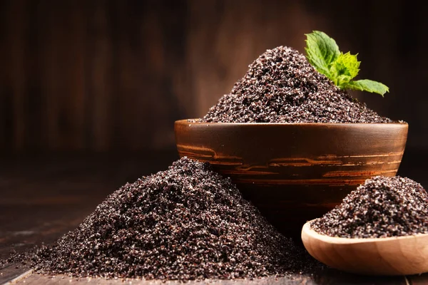 Ahşap masa üzerinde haşhaş tohumu kase ile kompozisyon