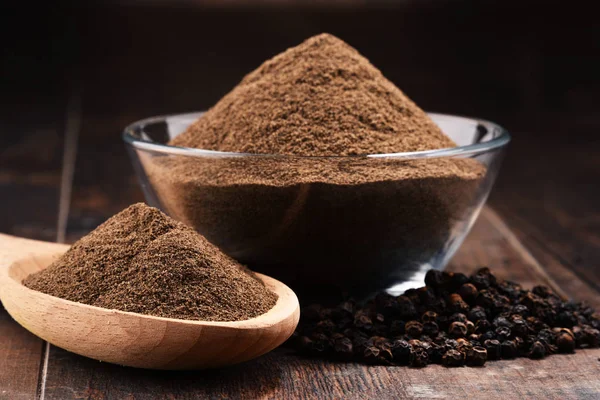 Composition with bowl of ground black pepper on wooden table — Stock Photo, Image