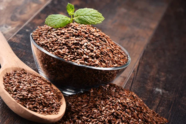 Composition with bowl of flax seeds on wooden table — Stock Photo, Image