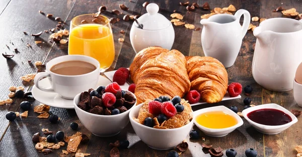 Morgenmad serveret med kaffe, juice, croissanter og frugt - Stock-foto