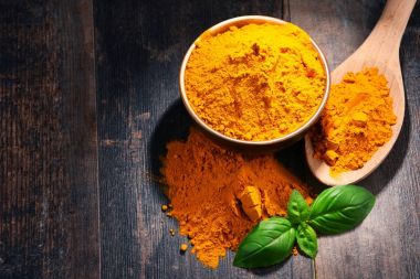 Ahşap masa üzerinde zerdeçal tozu kase ile kompozisyon