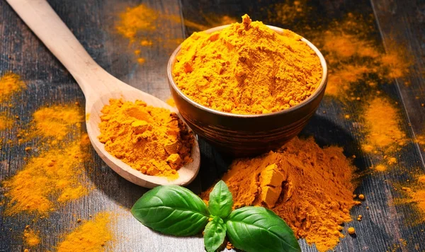 Composition with bowl of turmeric powder on wooden table — Stock Photo, Image