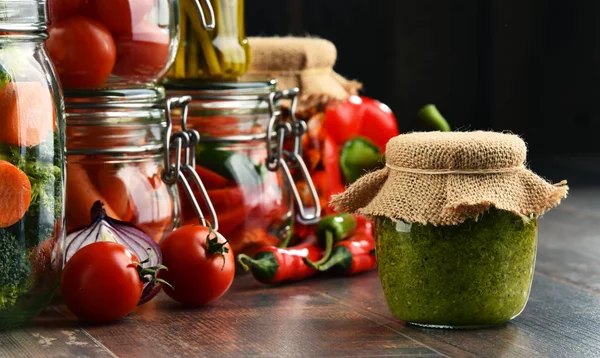 Frascos com alimentos marinados e produtos hortícolas orgânicos crus — Fotografia de Stock