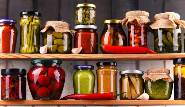 Frascos con variedad de verduras en vinagre. — Foto de Stock