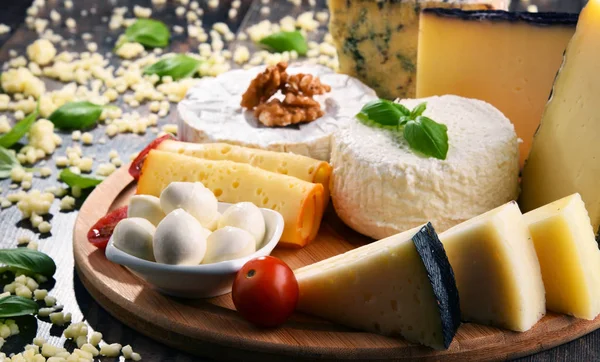 Different sorts of cheese on kitchen table — Stock Photo, Image