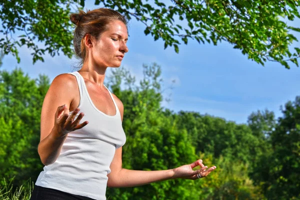 Ung kvinna under yoga meditation i parken — Stockfoto