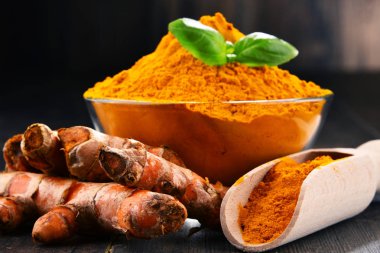 Ahşap masa üzerinde zerdeçal tozu kase ile kompozisyon