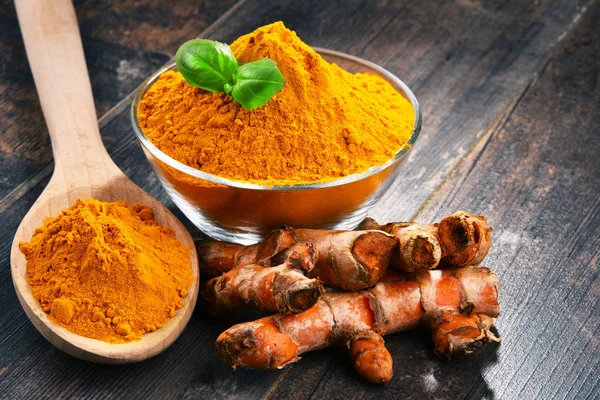 Composition with bowl of turmeric powder on wooden table — Stock Photo, Image