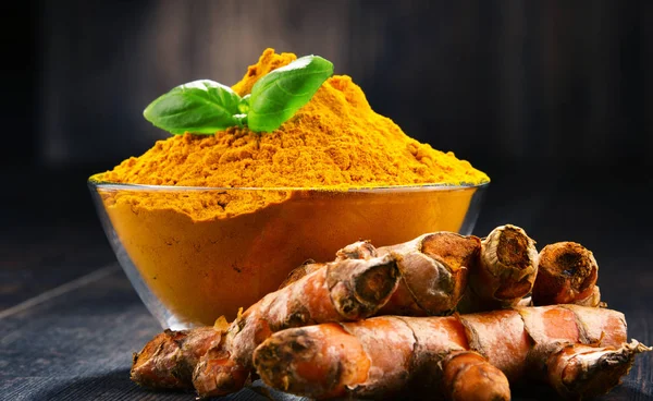 Compoziție cu castron de pulbere de turmeric pe masă de lemn — Fotografie, imagine de stoc